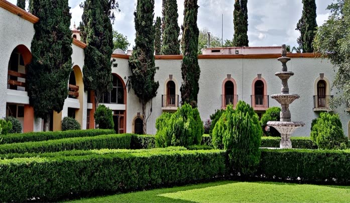 Edificio del hotel con fuente y jardín